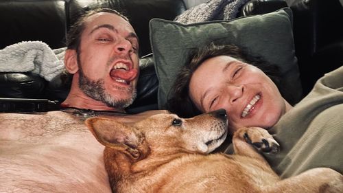 Full length of man and dog relaxing at home