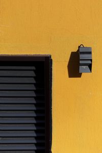 Close-up of yellow mailbox on wall