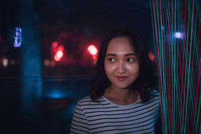 Cheerful optimistic asian girl smiling, neon light background