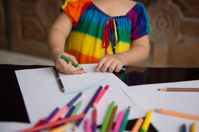 Midsection of woman holding paper with text on table