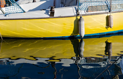 Sailboats moored at harbor