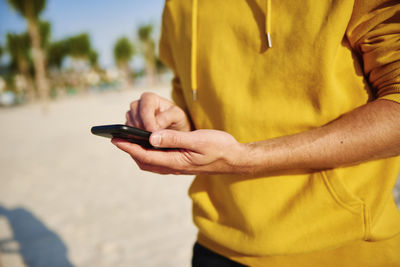 Midsection of man using mobile phone