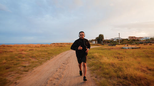 Man with headphone running outdoor during rain day