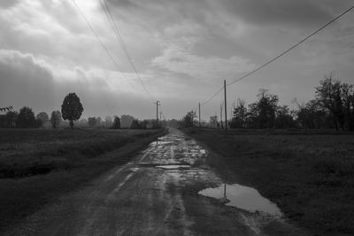 Road amidst field against sky