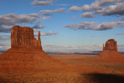 Rock formations on landscape against cloudy sky