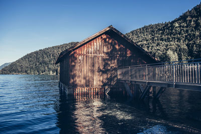 Built structure by lake against blue sky