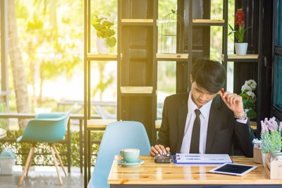 Businessman analyzing graph on table in restaurant