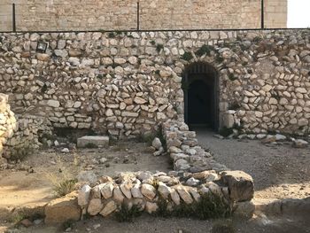 Stone wall by rocks against building