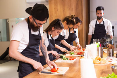 Rear view of man preparing food at table