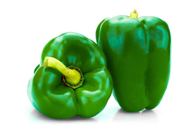 Close-up of green bell peppers against white background