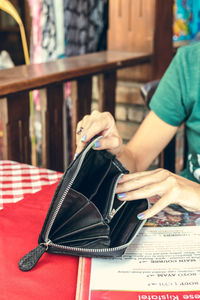 Midsection of woman reading book on table