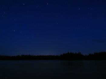Scenic view of lake against clear sky at night