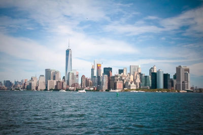 Scenic view of cityscape by sea against sky