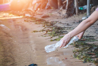 Midsection of woman holding umbrella in water