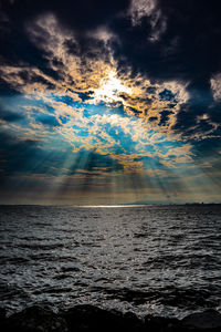 Scenic view of sea against dramatic sky during sunset