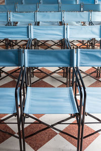 Empty textile chairs in row arranged on floor