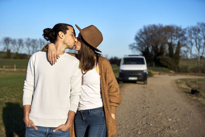 Friends standing on vehicle against sky