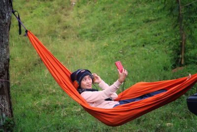 Rear view of woman sitting on grass