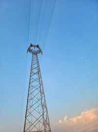 Low angle view of electricity pylon against clear sky