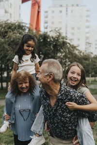 Playful grandparents and grandchildren enjoying at park