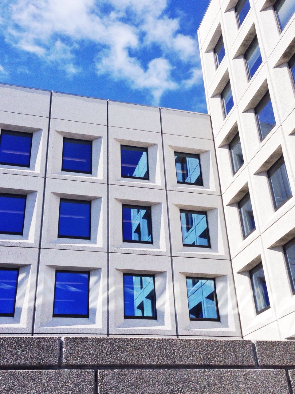 architecture, building exterior, built structure, window, low angle view, blue, sky, building, pattern, cloud - sky, day, repetition, outdoors, facade, glass - material, cloud, full frame, no people, in a row, city