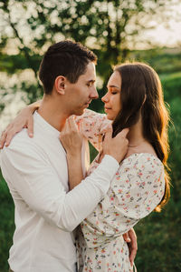 Side view of young woman eating food at park
