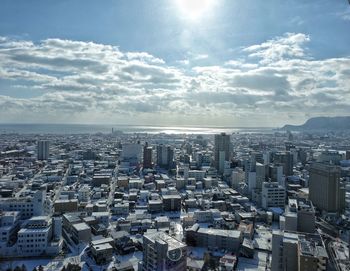 Aerial view of city against cloudy sky