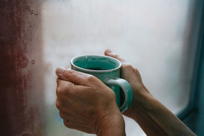 Cropped image of hand holding coffee cup