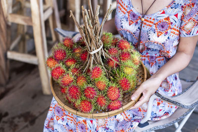 Midsection of woman holding strawberries