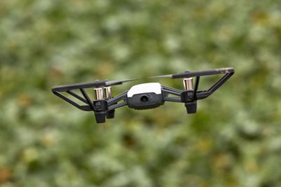 Hovering black and white photo drone with four rotor blades flying in the air