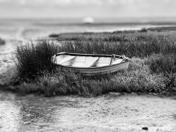 Boat moored on shore against sea