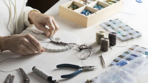 High angle view of woman working with thread on table