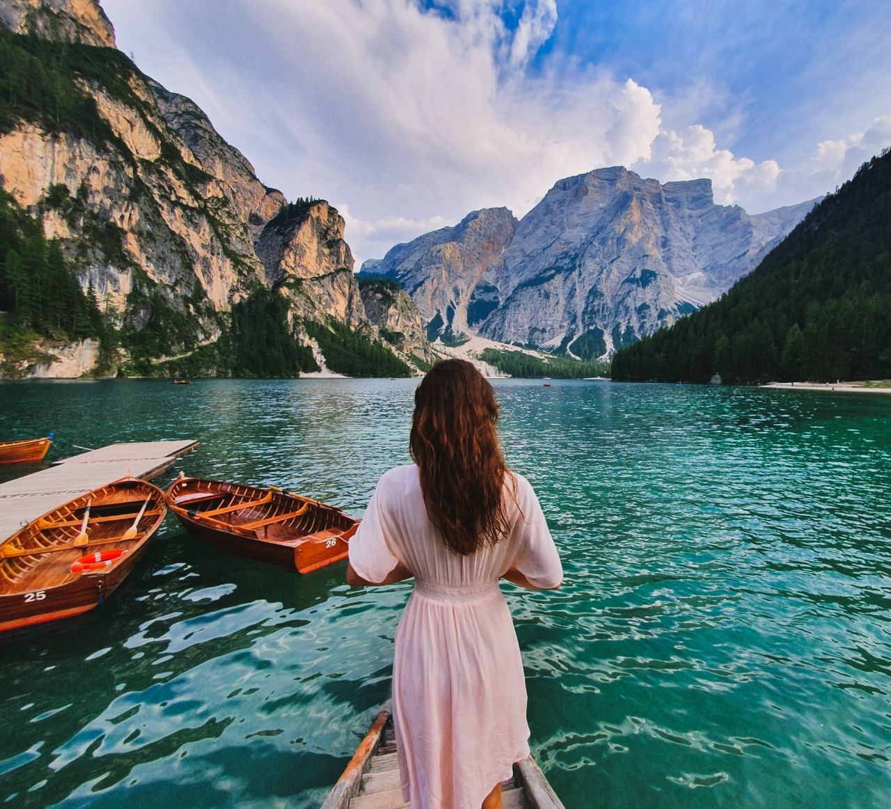 water, mountain, rear view, real people, leisure activity, beauty in nature, one person, lifestyles, scenics - nature, sky, women, mountain range, adult, nature, nautical vessel, tranquil scene, three quarter length, transportation, standing, hairstyle, outdoors