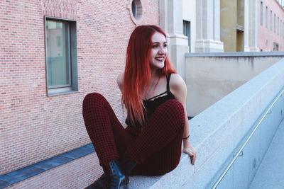 Portrait of smiling young woman sitting outdoors