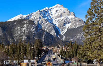 Panoramic view of snowcapped mountains against sky and township 