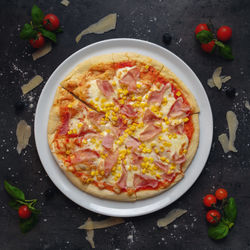 Delicious italian style pizza with ham and corn,  appetizing background