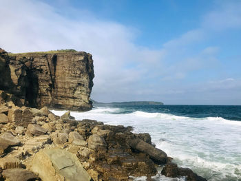 Scenic view of rocks on beach against sky