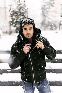 Young man standing in snow during winter