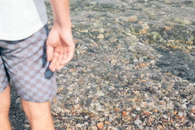 Low section of person standing on pebbles