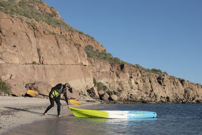 One woman getting ready to jump on a kayak at carmen island in baja california.