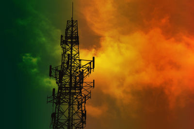 Low angle view of silhouette communications tower against sky during sunset