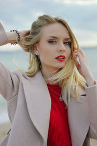 Portrait of a beautiful young woman with red lips on the sea