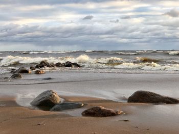 Rocks on beach against sky