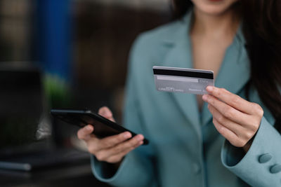 Midsection of woman using mobile phone