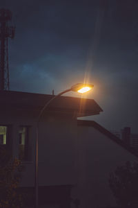 Low angle view of sun streaming through silhouette building against sky