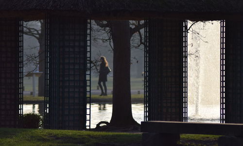 Silhouette man standing by window of building