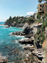 Scenic view of sea by buildings against sky