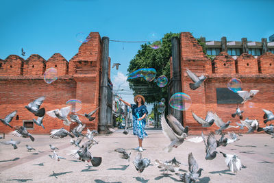 People on cobblestone street against buildings