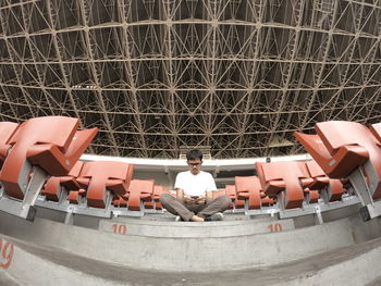 Digital composite image of man sitting in modern building