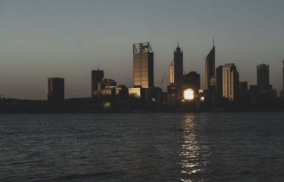 Illuminated buildings in city against sky